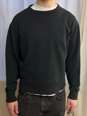 Svart sweatshirt från Acne Studios - Svart crewneck sweatshirt från Acne Studios. Har varit en favorittröja men har nu gått sönder på armarna. En skräddare lagade ena armen, den andra sidan kan säkert också lagas av någon som är duktig på att sy.
