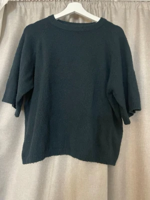  stickad tröja trekvartsärm - Mysig stickad tröja från 157 med rund halsringning och kortare ärmar. Tröjan har en enkel och avslappnad passform, perfekt för lager på lager. Ribbstickade detaljer vid hals, ärmslut och nederkant. Materialet känns mjukt och bekvämt.