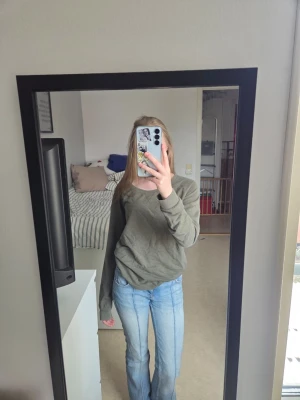 Olivgrön sweatshirt - Säljer en olivgrön oversized sweatshirt med rund hals och långa ärmar. Tröjan har en avslappnad passform och är tillverkad i mjukt material, perfekt för en chill och enkel stil. Inga synliga loggor eller tryck.