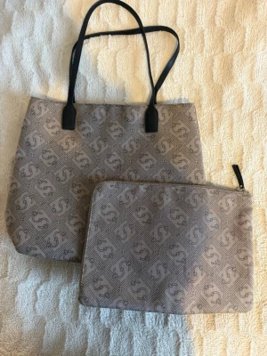 Snyggt väskset med 2 väskor - Säljer ett snyggt och stilrent väskset i beige. Setet består av en stor väska som är prefekt för vardag eller jobb samt en liten mindre fodral/väska som passar t.ex dator, surfplatta eller mindre saker. Skicket är väldigt fint 