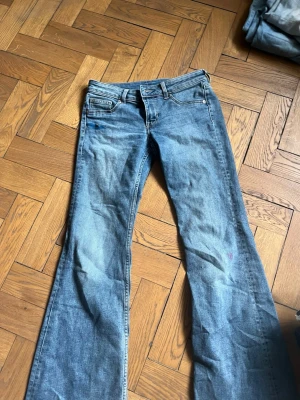 Blå bootcut jeans med utsvängda ben - Säljer ett par klassiska blå bootcut jeans med utsvängda ben och femficksmodell. Jeansen har normalhög midja och är gjorda i ett mjukt denimtyg. Perfekta för dig som gillar retrostil och vill ha ett par jeans som sticker ut lite extra. De har defekter av färg , jag är rätt säker att de går bror rätt lätt