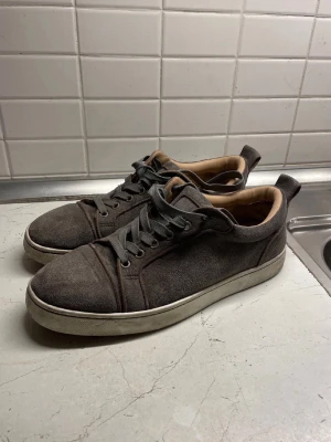 Grå mockasneakers med vita sulor - Snygga grå sneakers i mocka med vita gummisulor och svarta skosnören. Skorna har en stilren design med rund tå och diskreta sömmar. Insidan är ljusbrun och de har en praktisk ögla bak för enkel påtagning. Box, dustbag och annat följer med! Kom gärna med frågor eller prisförslag. Skickar snabbt 💨 !
