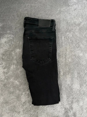 Svarta slim jeans  - Säljer ett par svarta slim jeans ifrån märket Jack and Jones. Skick 9/10 nypris - 899kr säljs - 149kr! Vid minsta fundering bara att höra av sig!☑️