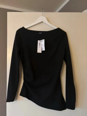 Oanvänd svart asymmetrisk topp från ginatricot - Oanvänd svart långärmad topp från ginatricot asymmetrisk. lapp kvar 