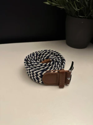 Flätat bälte blå vitt - Ett riktigt snyggt flätat bälte. Bältet är blå vitt och passar till det mesta. Skicket är otroligt bra då de endast är använt någon enstaka gång. Skriv vid frågor och kolla gärna in min profil för fler bälten och kläder!