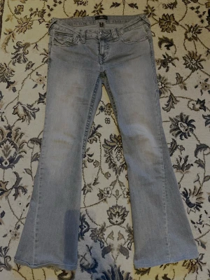 Ljusblå flare jeans ’Joey’ True Religion - Säljer ett par ljusblå jeans från True Religion, modell Joey Low Rise Flare. Jeansen har låg midja, utsvängda ben och klassisk femficksdesign. Perfekta för dig som gillar en classic chic stil. Skulle också kunna tänka mig att byta dessa jeans i utbyte mot ett par andra snygga. 