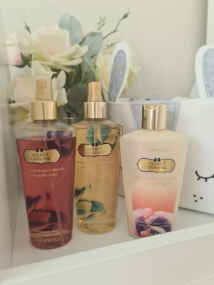 Victoria's Secret Secret Craving set - Säljer ett set med Victoria's Secret Secret Craving, innehållande två body mists och en body lotion. Flaskorna är i plast med guldiga detaljer. Doften har inslag av svartvinbär och vanilj. Perfekt för dig som gillar söta och fruktiga dofter. Ena misten har bleknat och luktar sämre. Krämen är nästan helt slut. Andra misten luktar bra. Säljer nu av min vintage kollektion. Perfekt för samlare. Eftersom dofterna är vintage kan lukten skilja sig markant från nya, och köps därmed på eget bevåg.