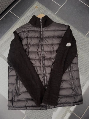 Moncler Cardigan - Säljer nu denna Moncler Cardigan, perfekt till sommarkvällar!                                                              Bra skick, finns lite små flaws.                                    Storlek L, passar nog även M (kan skicka mått). Om du har några fler funderingar så är det bara att höra av sig!                                                               Pris ej hugget i sten! :)