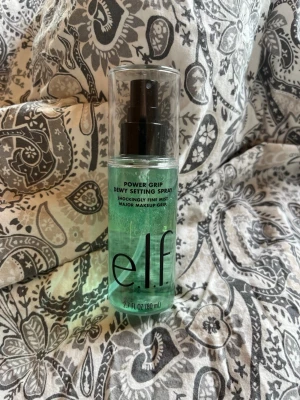 e.l.f. Power Grip Dewy Setting Spray - Fräsch face mist från e.l.f. i en genomskinlig plastflaska med svart spraymunstycke. Innehållet är ljusgrönt och flaskan rymmer 80 ml. Perfekt för att fixera makeup och ge huden en daggig finish.Har används en gång