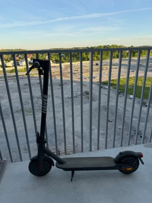 NAVEE Eazy ride 20 svart elscooter - Säljer en svart elscooter från NAVEE med robust ram i metall och bred ståplatta. Scootern har stora hjul, handbroms och LED-belysning fram. Perfekt för smidig transport i stan eller till skolan. Laddas enkelt via eluttag. Är laglig motor kraft 250W Max hastighet 20km/h