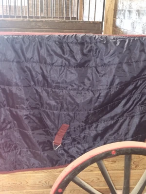 Mörkblått stalltäcke för häst  - Säljer ett mörkblått hästtäcke från Jackie med vinröda detaljer och kantband. Täcket är tillverkat i slitstarkt syntetmaterial och har metallspännen för enkel fastsättning. Perfekt för stall eller hage.
