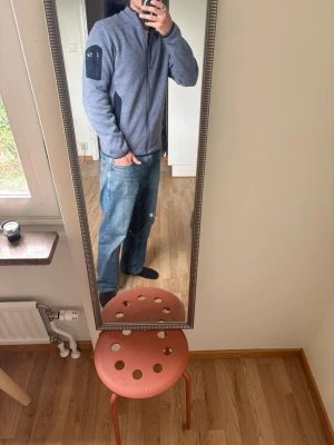 Grå fleecetröja från Arc'teryx - Snygg grå ziptröja från Arc'teryx med hel dragkedja och hög krage. Tröjan har svarta detaljer på ärmarna och två sidofickor med dragkedja. Perfekt för lager-på-lager och enkel att matcha med jeans eller andra byxor.