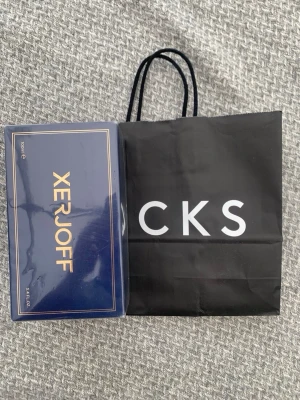 Xerjoff parfym 100ml lyxig förpackning - Exklusiv parfym från Xerjoff i en elegant mörkblå kartong med gulddetaljer. Förpackningen rymmer 100 ml och utstrålar lyx och stil. Perfekt för dig som vill ha något unikt och sofistikerat i din doftsamling.