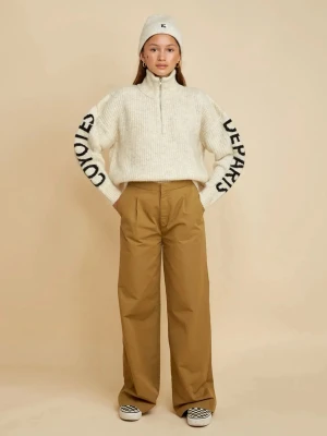 Beige stickad tröja från Les Coyotes de Paris - Stickad beige tröja från les coyotes de paris med halv dragkedja och hög krage. Svart texttryck på båda ärmarna. Oversized passform och ribbstickad struktur. Perfekt för en avslappnad och trendig look. Grovstickad kvalitet i mohair/ull. Nypris ca 2500kr. Storlek 14 år men passar mig som är 171 cm.