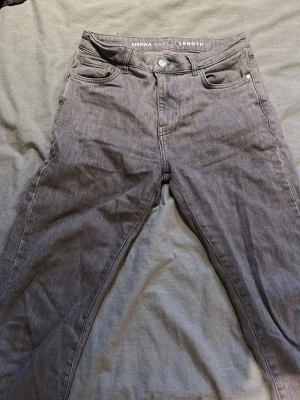 Grå jeans från Sienna, midja 27 - Snygga grå jeans från Sienna med klassisk femficksdesign och raka ben. Jeansen har midja 27 och längd 32, perfekt för dig som gillar en stilren och enkel look. Tillverkade i mjukt denimtyg som sitter skönt hela dagen.