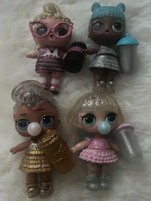 Fyra LOL Surprise dockor - Säljer ett jättefint paket med 4 glittriga LOL-dockor från populära glitter-serier. Alla dockor är i superfint skick, har sina outfit/skor och kommer med matchande flaskor! Perfekt som samlarobjekt eller present. Säljs som ett set! Om ni har frågor skriv gärna till mig!❤️