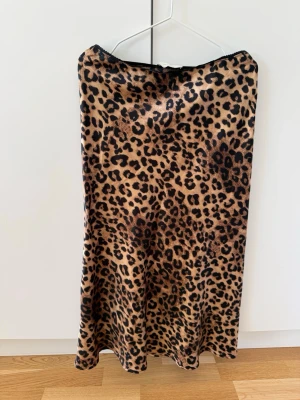 Leopardmönstrad långkjol - Snygg långkjol från Neo Noir med leopardmönster i storlek 38. Satinmaterial, med en liten rosett längst fram. Använd fåtalet gånger. Nypris 599 kr. Kolla gärna in mina andra annonser så samfraktar jag! Skicka gärna prisförslag 🫶🏼