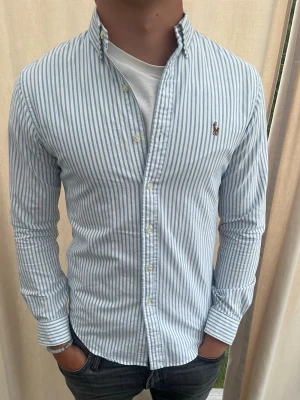 Randig skjorta från Ralph Lauren - Otroligt snygg randig skjorta från Ralph Lauren. Som ny, använd typ 2 gånger. Strl S, personen på bilden är 185 cm lång. Skicka gärna prisförslag. Kika in min profil för mer schyssta plagg