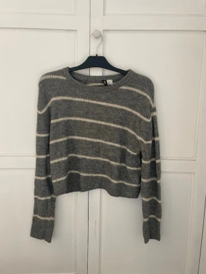 Gråvit randig stickad tröja H&M - Mysig stickad tröja från H&M i grått med vita  ränder. Använd men i bra skick. 