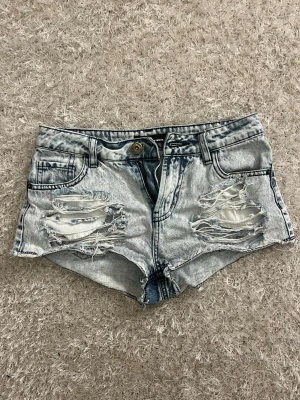 Ljusblå lågmidjade shorts från Tally Weijl - Snygga ljusblå denimshorts från Tally Weijl med slitna detaljer