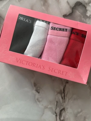 3-pack ribbade trosor Victoria's Secret - Säljer ett 3-pack ribbade trosor från Victoria's Secret i färgerna svart, vitt, rosa och rött. Trosorna har bred resår med logga och spetsdetaljer längs kanterna. Perfekta för dig som gillar både komfort och snygg design.