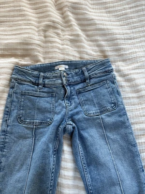 Blå bootcut jeans med stora fickor - Säljer ett par blå bootcut jeans från Ginatricot, dem är upsprättade längstner och har även hål längstner och därför kommer jag att sälja dem billigt, skit snygga och perfekta 💓