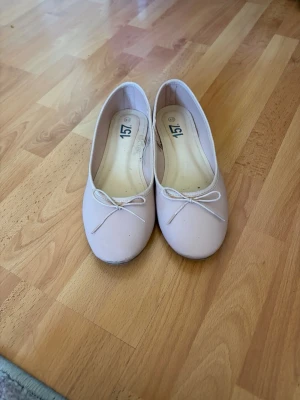 Ljusa ballerinaskor med rosett - Snygga ljusrosa ballerinaskor från 157 med rund tå och söt liten rosett framtill. Skorna har en klassisk och enkel design med tunn sula och mjukt material, perfekta för en stilren look. 