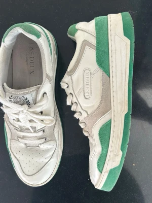 Vita och gröna sneakers från Les Deux - Snygga sneakers från Les Deux i vitt och grönt med klassisk låg profil. Skorna har perforerad tå, gröna detaljer i mocka och läder samt vita skosnören. 