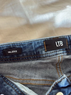 Blå bootcut jeans från LTB - Säljer ett par blå jeans från LTB, modell VALERIE. Jeansen har klassisk femficksdesign, bootcut passform och snygga kontrastsömmar. Perfekta för dig som gillar en tidlös och avslappnad stil.