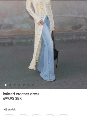 Lång stickad klänning i ljus beige - Trendig lång stickad klänning i ljus beige med virkade detaljer och slits framtill. Klänningen har lång ärm och figurnära passform, perfekt för dig som vill ha en cool och avslappnad look. Har den i xs m och S ifall ni köper skriv i chatten Vilken ni vill att ja postar