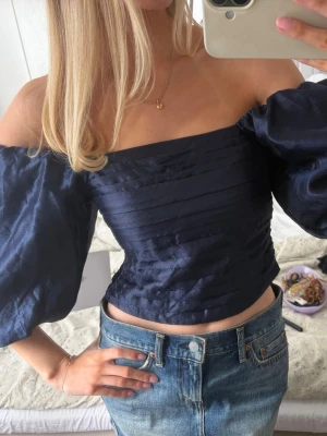 Mörkblå offshoulder topp med puffärmar - Mörkblå jättesnygg topp. Kan bäras som vanligt eller off shoulder🌸 Ny med prislappen kvar