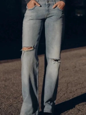 Ljusblå slitna raka jeans - Säljer ett par ljusblå jeans med raka ben och  slitningar på båda knäna. Säljes då dom ej används