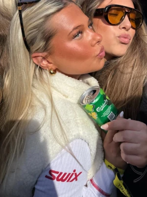 Vit Teddyväst - Snygg och fluffig vit dunväst med hög krage och tryckknappar framtill. Västen har en stilren design och är perfekt att slänga över en tröja för extra värme. Passar dig som gillar sportig och clean stil.