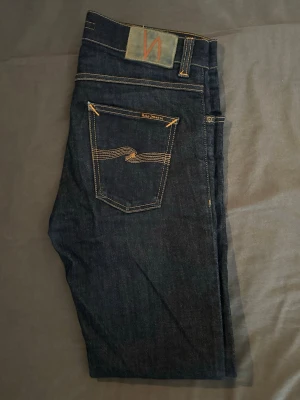 Mörkblå  Nudie Jeans - Säljer ett par klassiska mörkblå jeans från Nudie Jeans. Jeansen är slim fit modell med raka ben. Storlek W30 L32