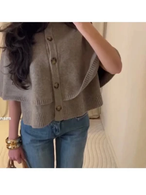 Grå beige stickad poncho - Supersnygg poncho men den kommer inte till användning, bara använd en gång. Skriv vid frågor! 