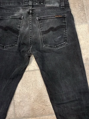Svarta jeans från Nudie Jeans - Säljer ett par svarta jeans från Nudie Jeans. Dem har snygga tvätt fläckar och är riktigt feta, perfekt till våren. Storlek är W31 och L32