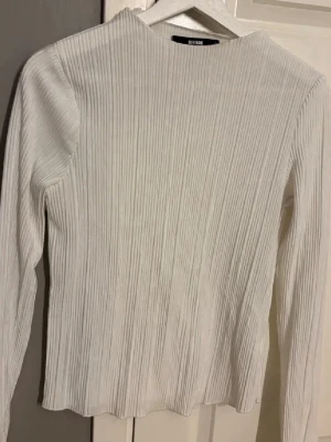 Vit ribbad långärmad tröja BikBok - Säljer en vit ribbad långärmad tröja från BikBok. Tröjan har rund halsringning och sitter snyggt på kroppen. Perfekt basplagg till garderoben och enkel att styla.