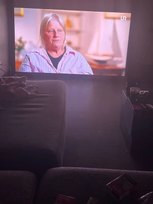 TCL 75" QLED 4K Smart TV (2023) - Stor 75-tums QLED 4K Smart TV från TCL, modell 2023. Skärmen har tunn ram och modern design, perfekt för streaming och gaming. Levereras med fjärrkontroll och smarta funktioner som appar och internetanslutning.