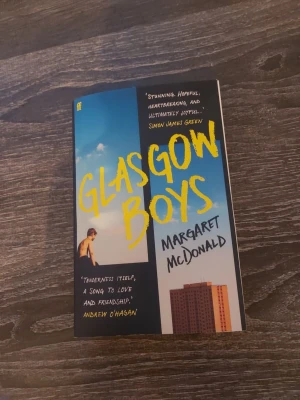 Glasgow Boys av Margaret McDonald - En samtida roman med färgstarkt omslag i blått och gult, skriven av Margaret McDonald. Boken handlar om två unga killar i Glasgow och deras kamp med vänskap, kärlek och att hitta sin plats i livet. Perfekt för dig som gillar gripande och realistiska berättelser.