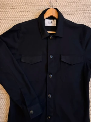 NN07 Overshirt  - Enligt oss den perfekta overshirten. Marinblå i Strl L i nyskick. Först till kvarn! Nypris: 2500kr. Vid fundering eller fler bilder tveka inte på att höra av er 🤝 / N&V