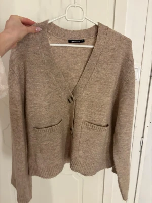 Beige kofta från Gina Tricot - Mysig beige kofta från Gina Tricot med två knappar framtill. Koftan är använd ett få tal gånger och i fint skick❣️