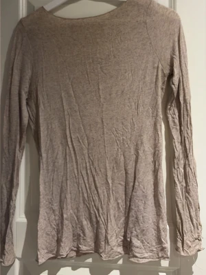 Beige långärmad topp från Intimissimi -  soperskön beige långärmad topp från Intimissimi i mjukt material med enkel och clean design. Perfekt basplagg med rund halsringning och smal passform. Tillverkad i en bomullsblandning som känns lätt och följsam. Den har två små hål på var sin ärm men inget som syns när man har på sig den så mycket!