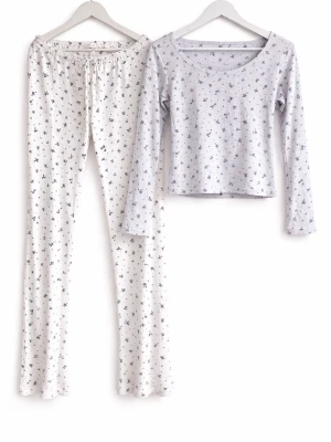 Blommig pyjamas från Nelly, L - Tvådelad pyjamas från Nelly i storlek L. Setet består av en långärmad topp och byxor med dragsko i midjan. Båda delarna är vita med små svarta blommor som mönster. Mjukt och bekvämt material, perfekt för mysiga kvällar hemma.