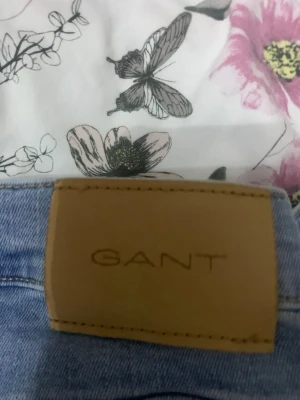 Ljusblå skinny jeans från GANT - Snygga ljusblå skinny jeans från GANT med klassisk femficksdesign och läderpatch bak i midjan. Jeansen har en smal passform och är tillverkade i mjukt denimtyg som ger en bekväm känsla. Perfekta för en avslappnad och trendig look.