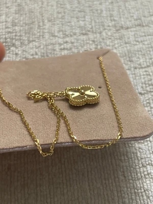 Guldigt halsband med fyrklöverhänge - Snyggt halsband au 750 guldpläterad med ett fyrklöverformat hänge.  Kedjan är tunn och elegant, perfekt för att lyfta vilken outfit som helst. Van clef inspirerad finns märke. Koppar är grund materialet, halsbandet är speciell beställning därför har den högsta kvaliteteten. Vattentålig. 42cm