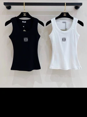 Svart och vit linnetopp  - Två stilrena linnetoppar  svart och vitt med broderad logga framtill. Topparna är ärmlösa, har rund halsringning och är tillverkade i 100% bomull för en mjuk och bekväm känsla. Perfekta att matcha med jeans eller kjol.Priset är angivet för två stycken, men man kan köpa en. Då blir priset 1100 kr.