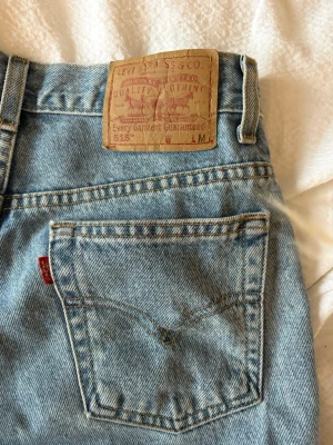 Levi's 501 ljusblå raka jeans - Klassiska Levi's 501 jeans i ljusblå denim med bootcut och femficksmodell. Jeansen har den ikoniska läderpatchen bak i midjan och röd Levi's-tagg på bakfickan. Tillverkade i slitstarkt bomullsmaterial.