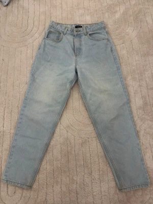 Ljusblå mom jeans PrettyLittleThing - Säljer ett par ljusblå mom jeans från PrettyLittleThing Petite. Jeansen har hög midja och raka ben. 