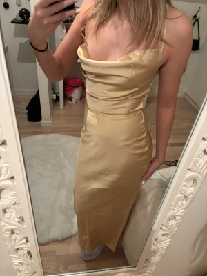 Gul satinklänning - Ljusgul satinklänning med öppen rygg samt liten dragkedja och band baktill från In the Style som ej är använd, perfekt till balen 💗