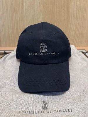  Brunello Cucinelli keps - Snygg marinblå keps från Brunello Cucinelli med broderad logotyp och text framtill. Kvitto och dustbag tillkommer ✨